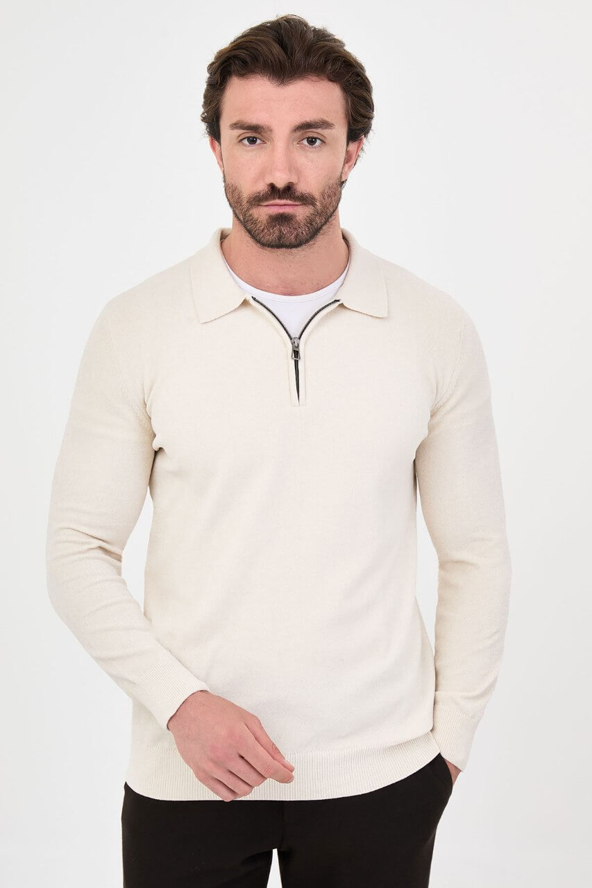 Men’s ecru polo neck knit sweater with zip collar detail styled with black trousers for a refined fall winter smart-casual outfit.