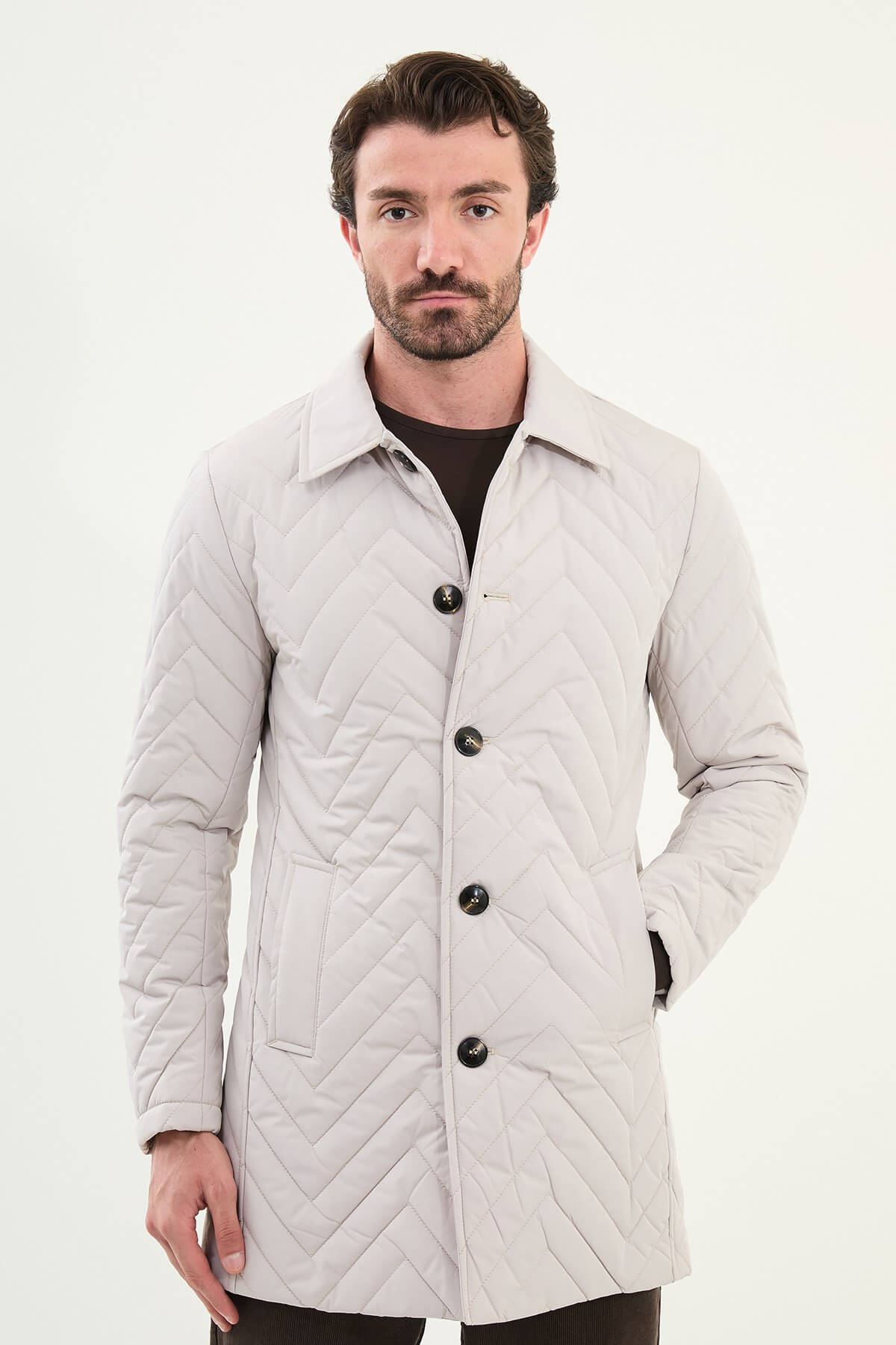 Men’s Ecru Quilted Slim Fit Car Coat with chevron stitching and button closure, styled with dark brown trousers and beige sneakers.