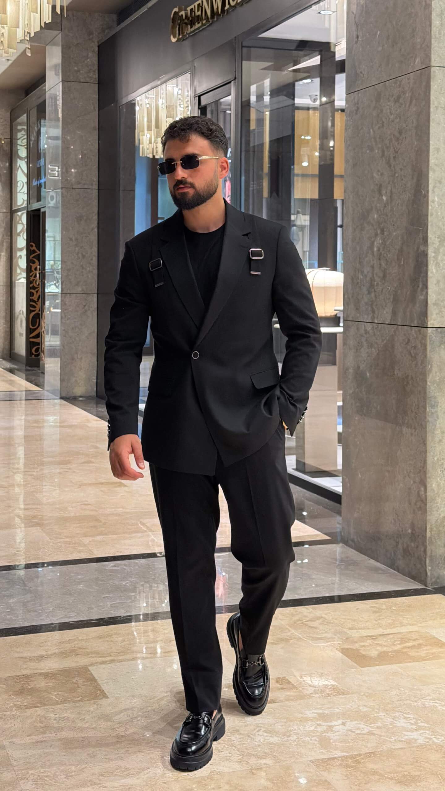 Men's black tailored fashion suit with modern strap detail styled with black T-shirt
