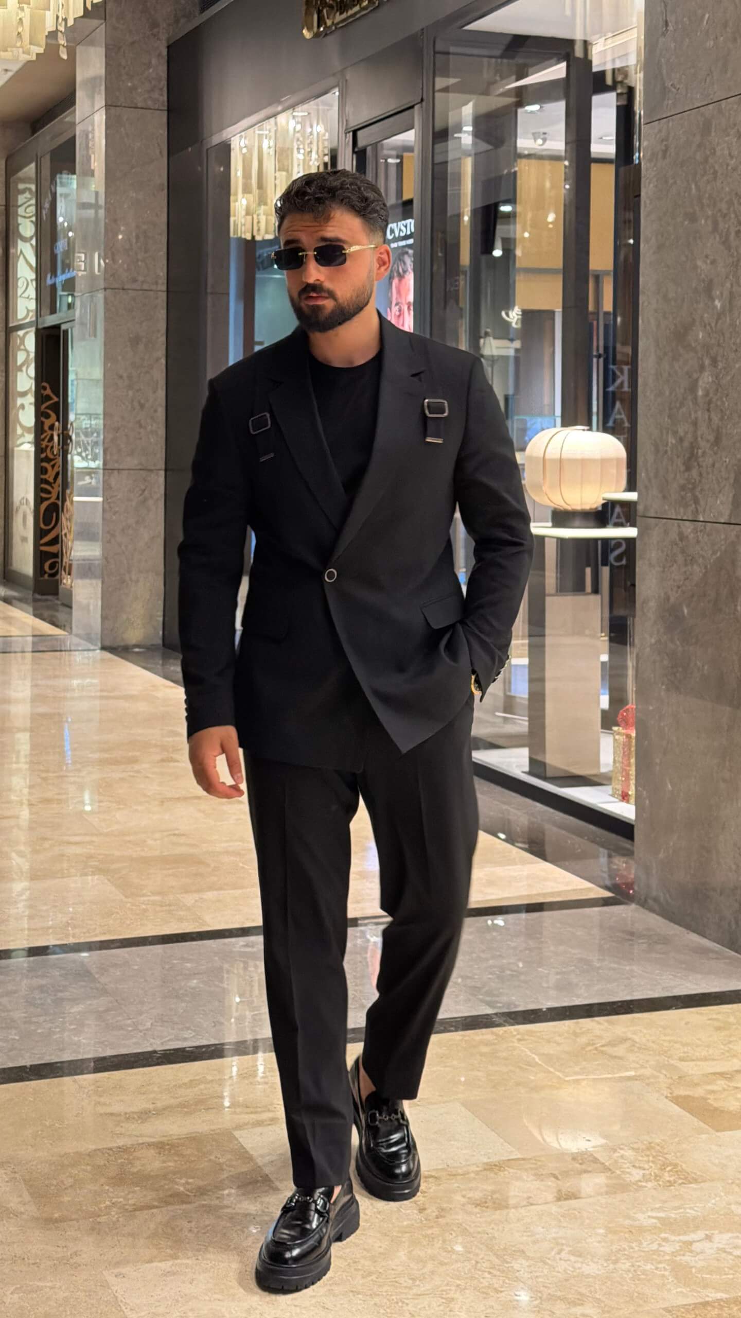 Men's black tailored fashion suit with modern strap detail styled with black T-shirt