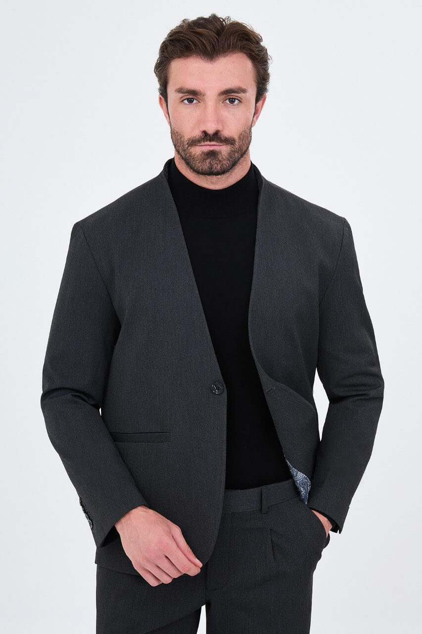 Full-length charcoal grey men's suit styled with a black turtleneck and black leather loafers for a contemporary smart-casual look.