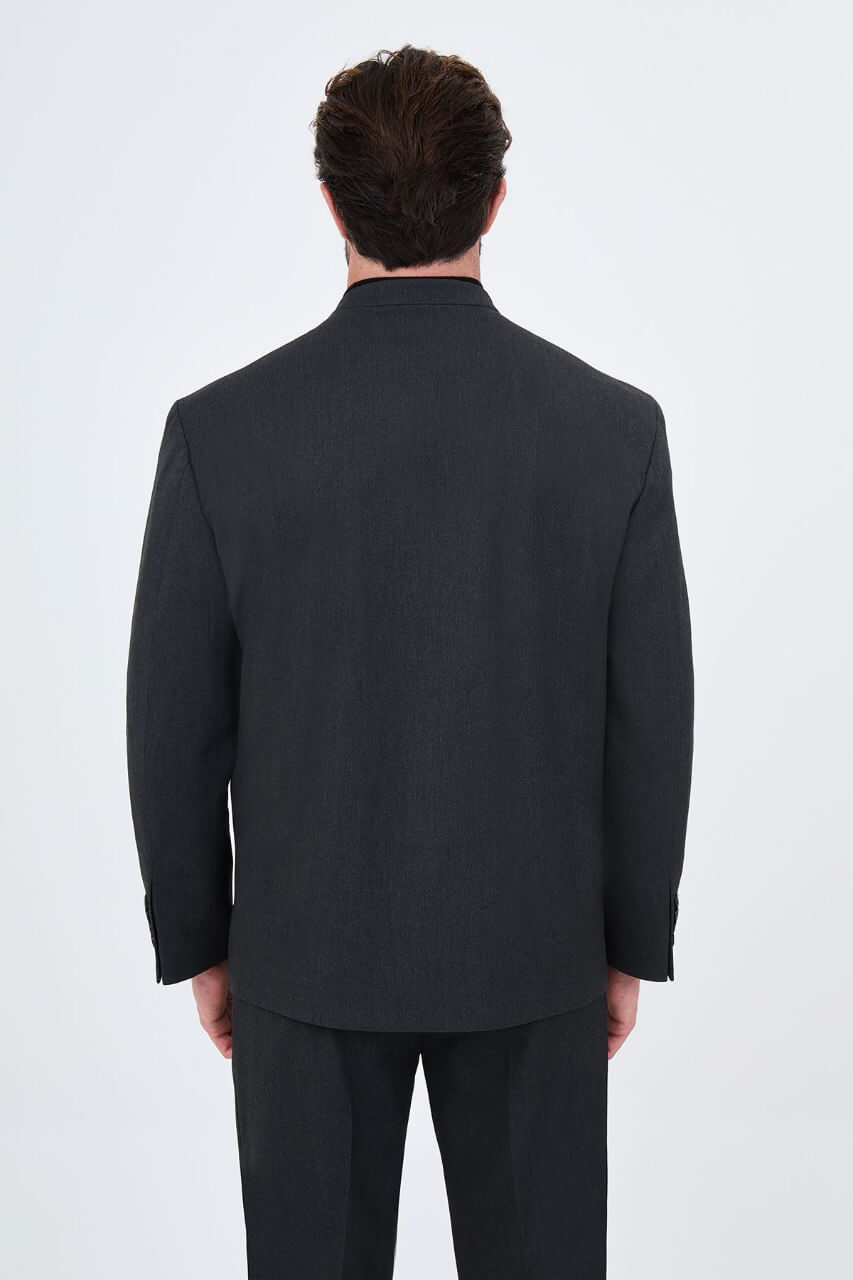 Full-length charcoal grey men's suit styled with a black turtleneck and black leather loafers for a contemporary smart-casual look.