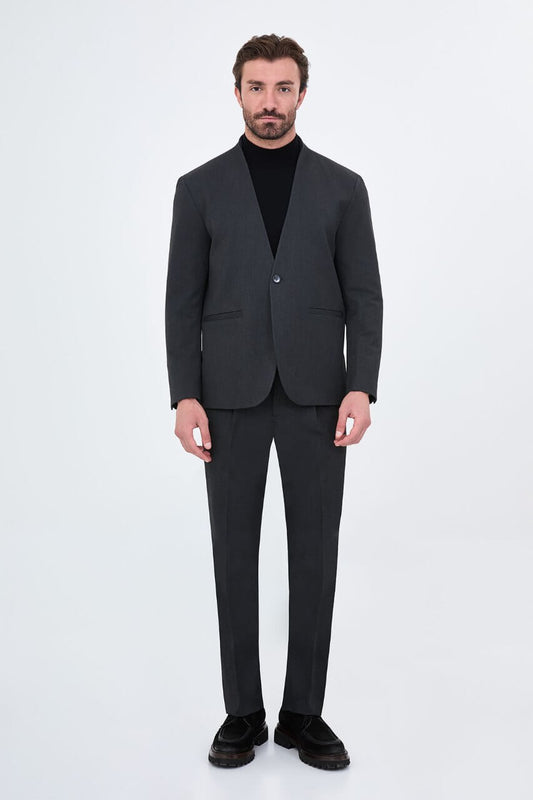 Full-length charcoal grey men's suit styled with a black turtleneck and black leather loafers for a contemporary smart-casual look.