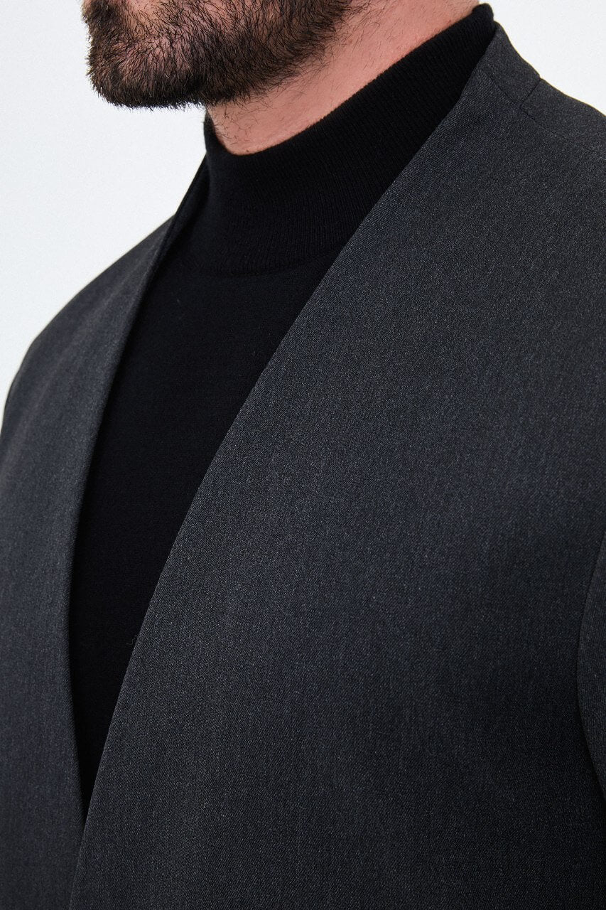Full-length charcoal grey men's suit styled with a black turtleneck and black leather loafers for a contemporary smart-casual look.