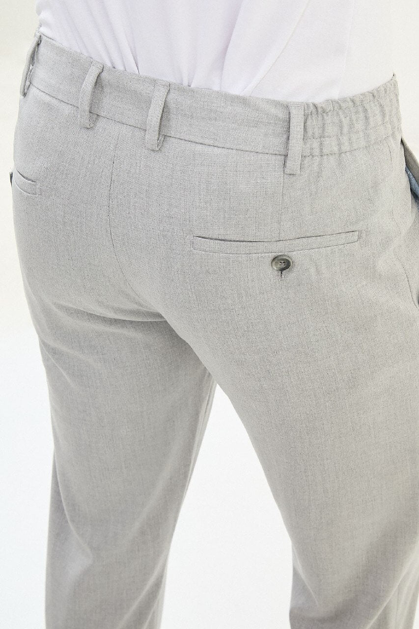 Men wearing gray slim-fit drawstring trousers with elastic waistband, tapered fit, styled with dress shoes and sneakers for versatile summer menswear.