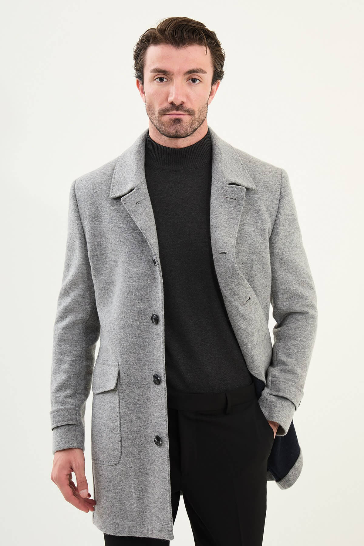 Man wearing a gray slim fit single-breasted peacoat with black turtleneck