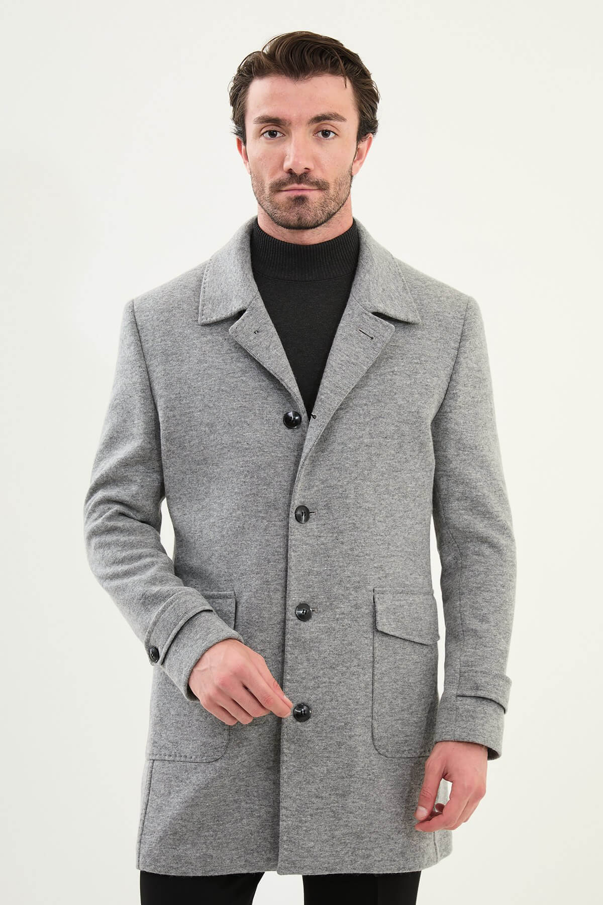 Man wearing a gray slim fit single-breasted peacoat with black turtleneck