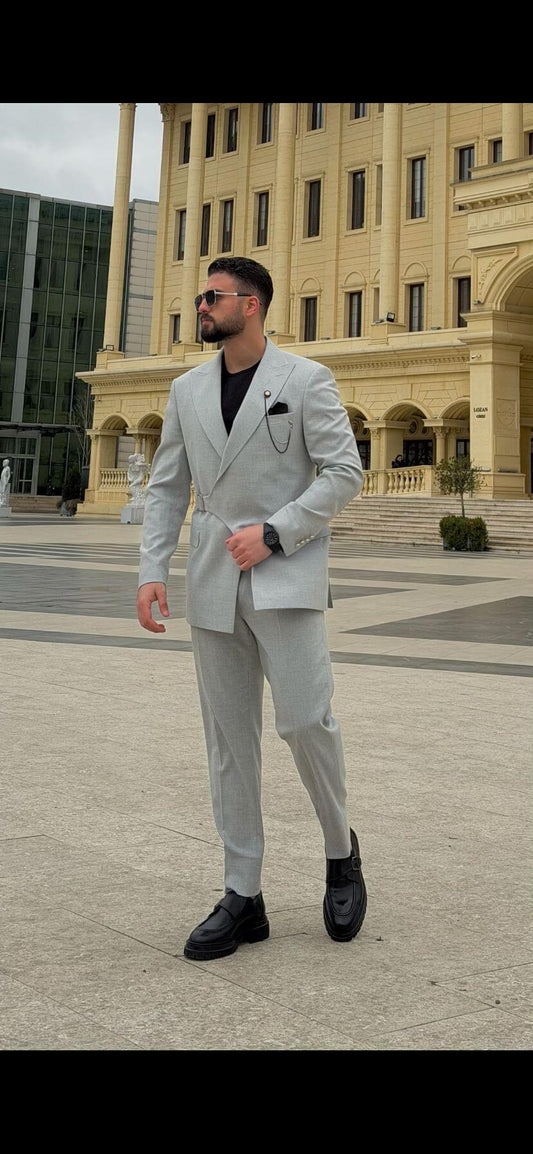 Light gray slim fit men’s suit styled with black loafers and black t-shirt. 