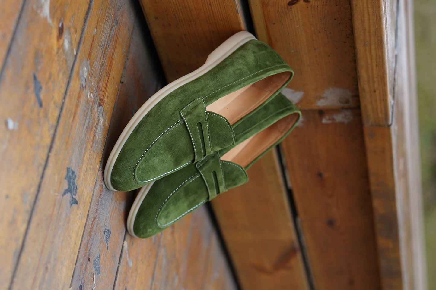 Men’s green suede leather penny loafers featuring classic vamp strap detail and lightweight sole.