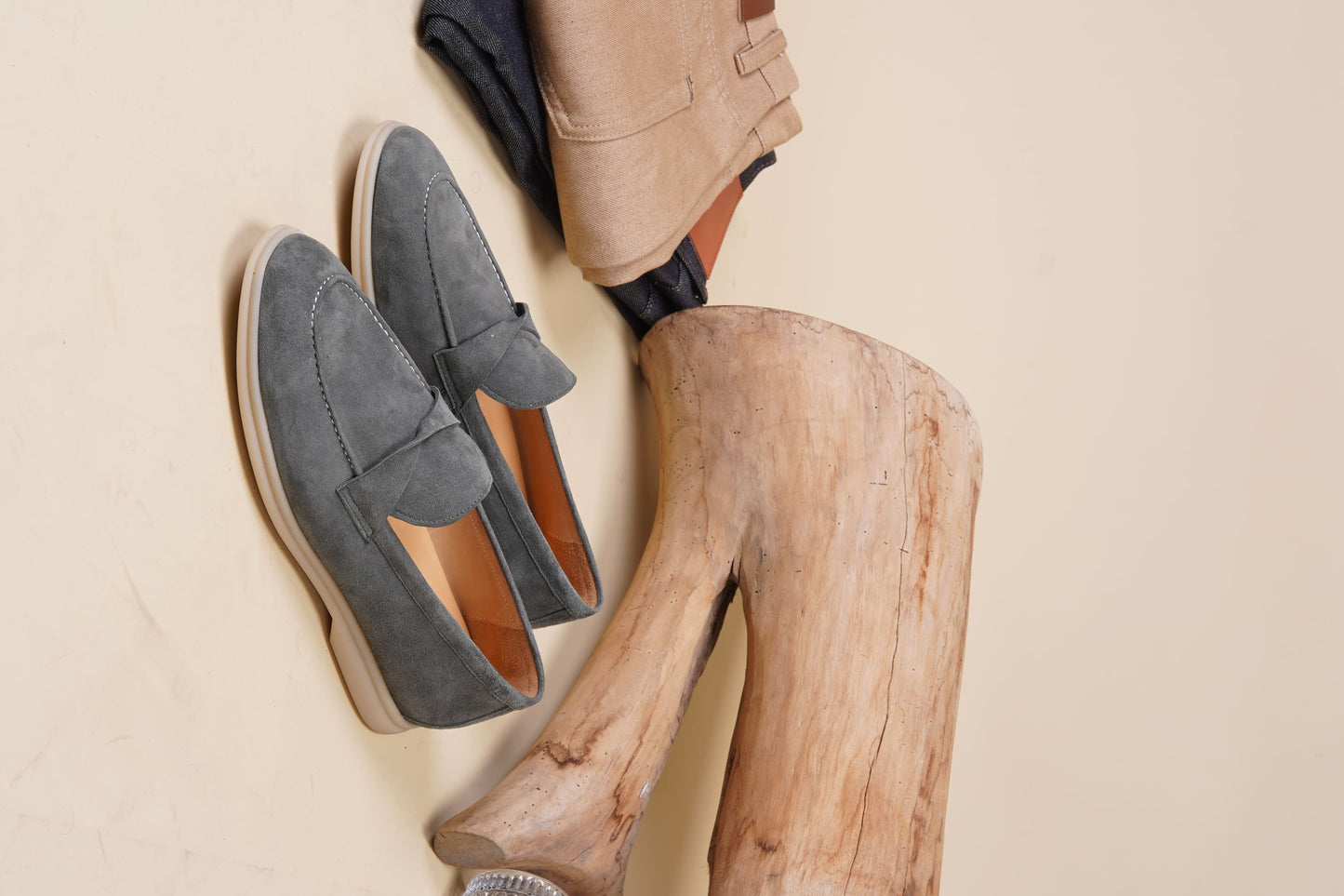 Men’s grey suede leather penny loafers featuring classic vamp strap detail and lightweight cream sole.