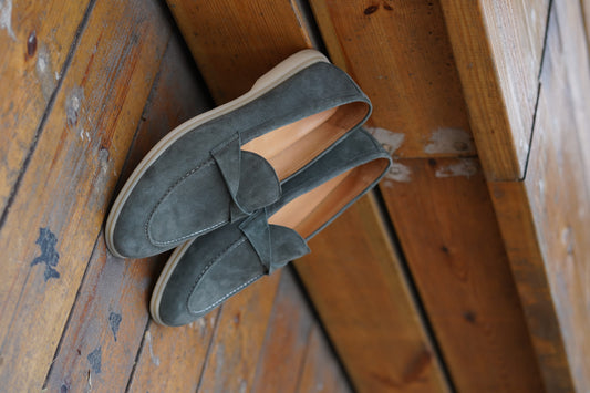 Men’s grey suede leather penny loafers featuring classic vamp strap detail and lightweight cream sole.