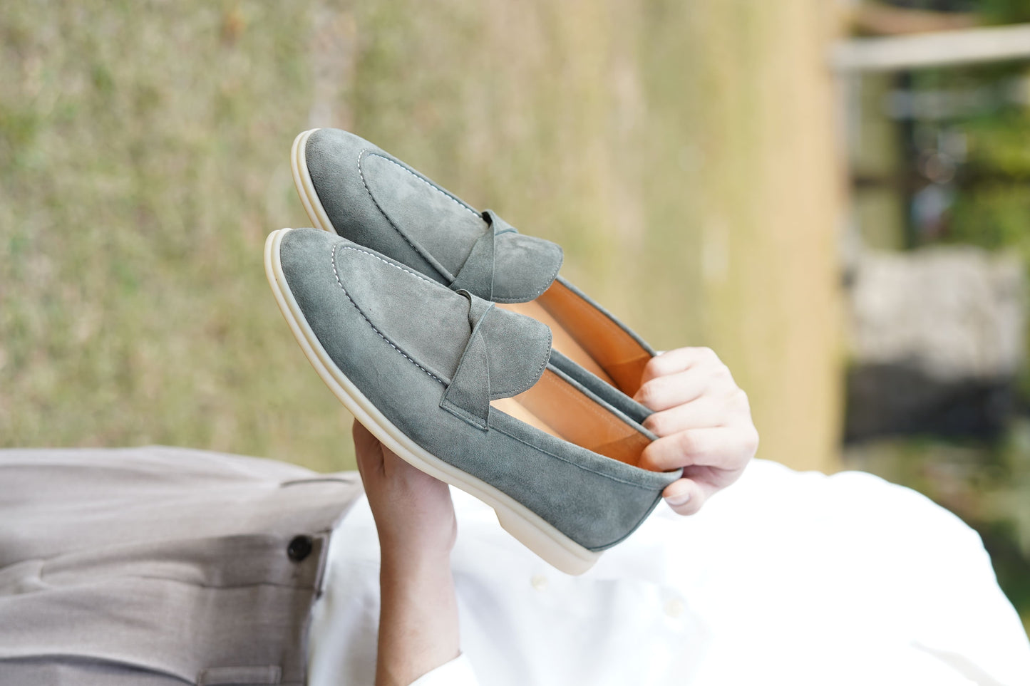 Men’s grey suede leather penny loafers featuring classic vamp strap detail and lightweight cream sole.