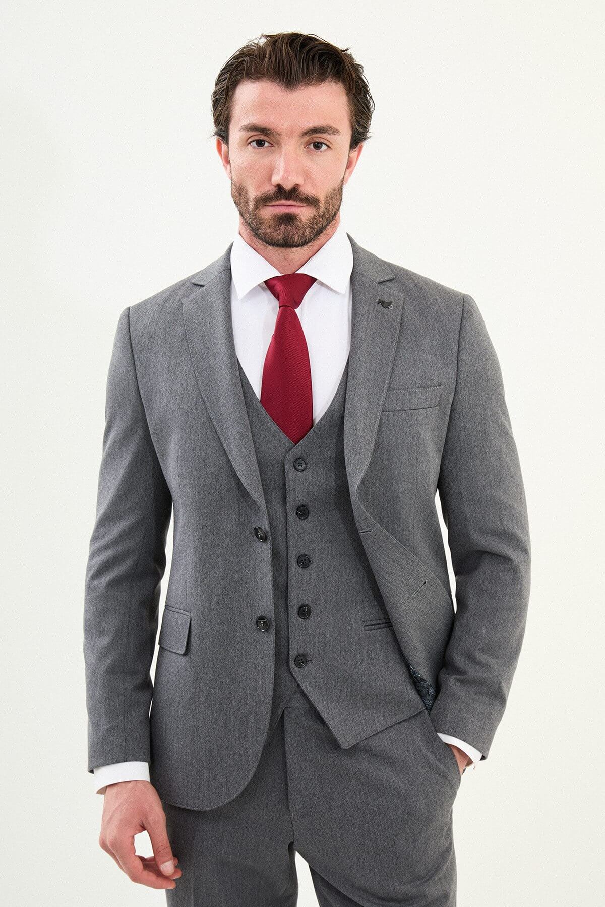Men’s micro-heathered gray slim-fit three-piece winter suit with single-breasted 2-button jacket, 5-button waistcoat, notch lapels with AMF stitching, and black origami lapel pin.