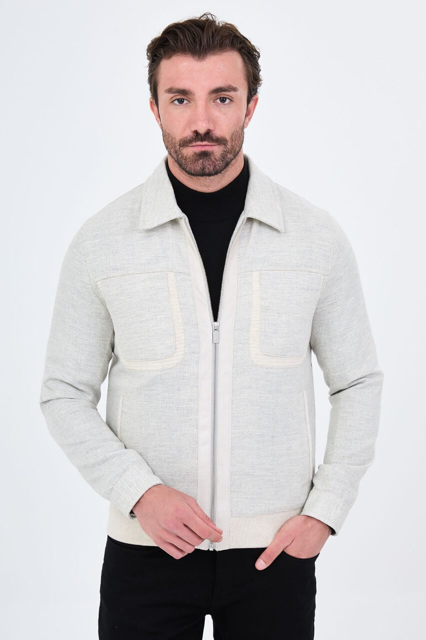 Light grey men's casual jacket styled with a black top and dark trousers.