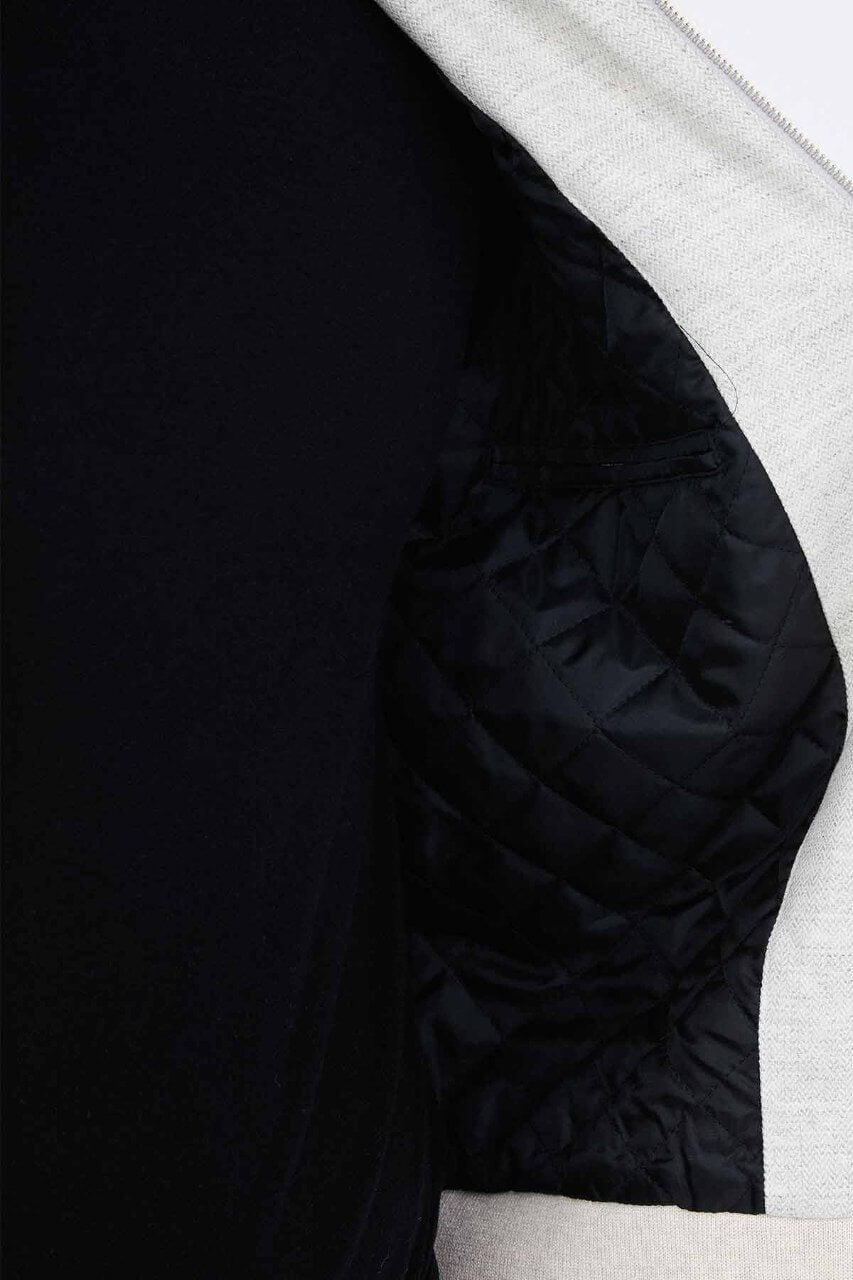 Light grey men's casual jacket styled with a black top and dark trousers.
