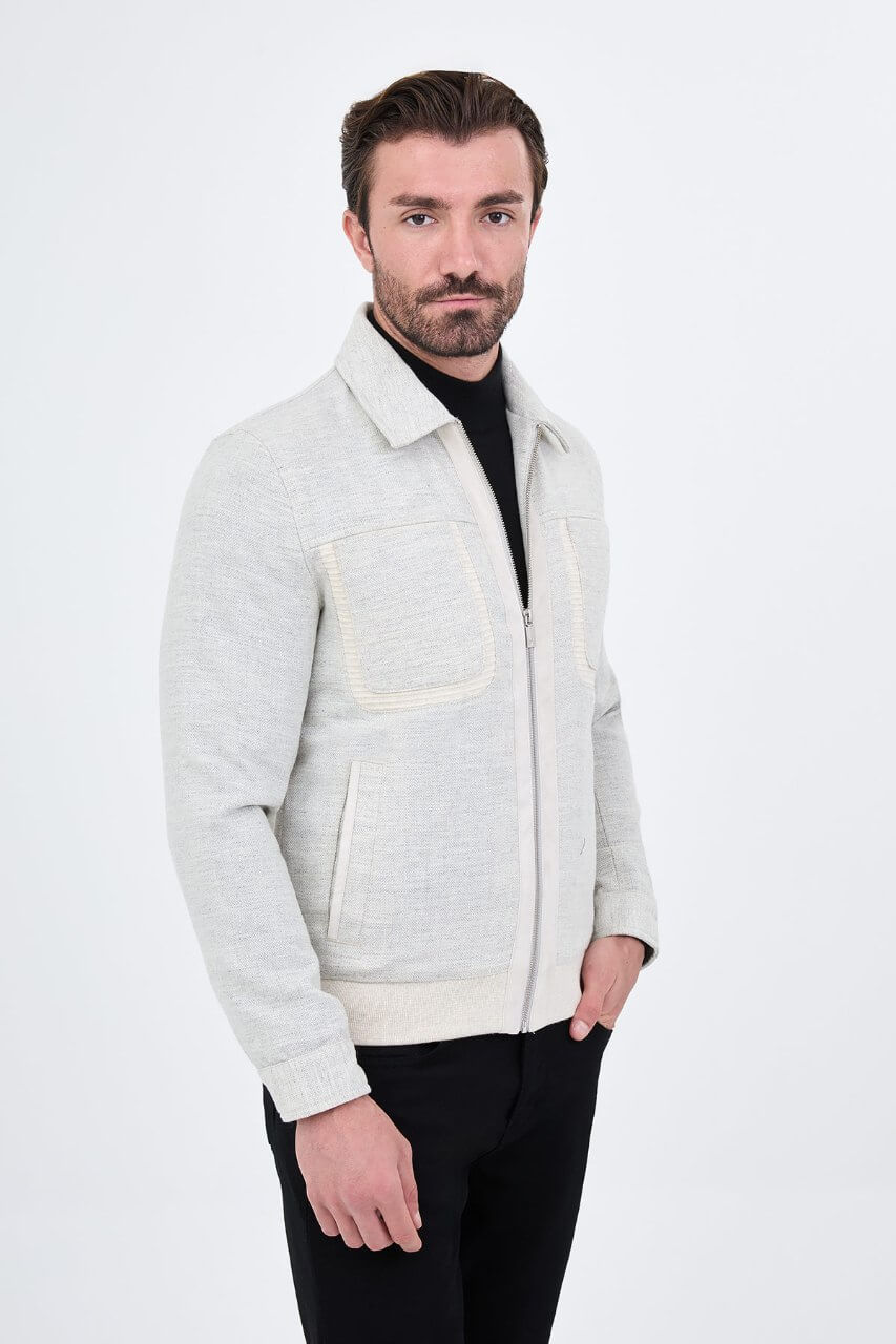 Light grey men's casual jacket styled with a black top and dark trousers.