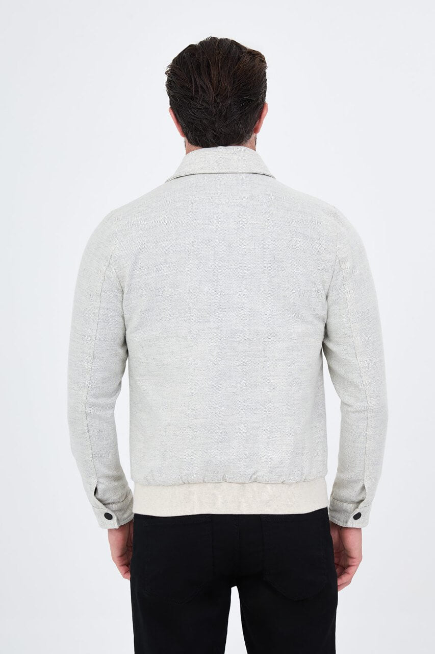 Light grey men's casual jacket styled with a black top and dark trousers.