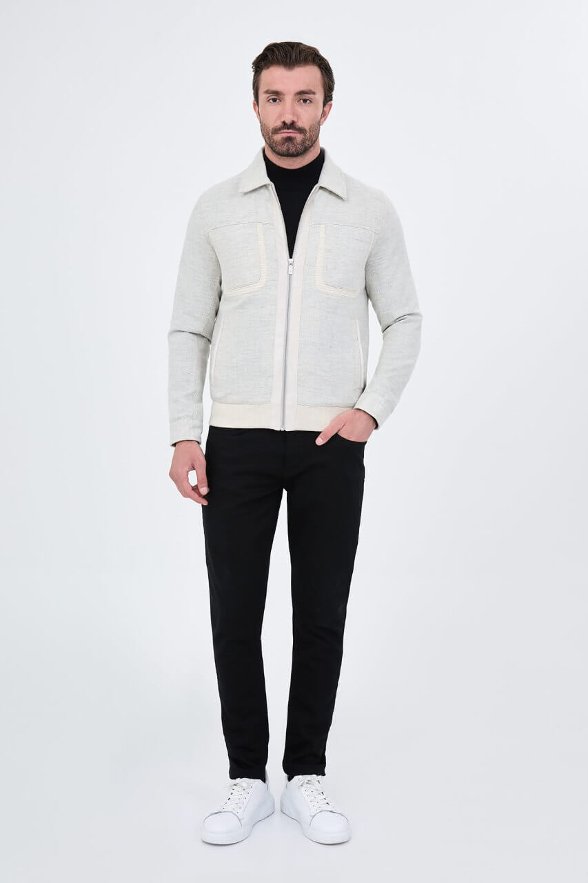Light grey men's casual jacket styled with a black top and dark trousers.