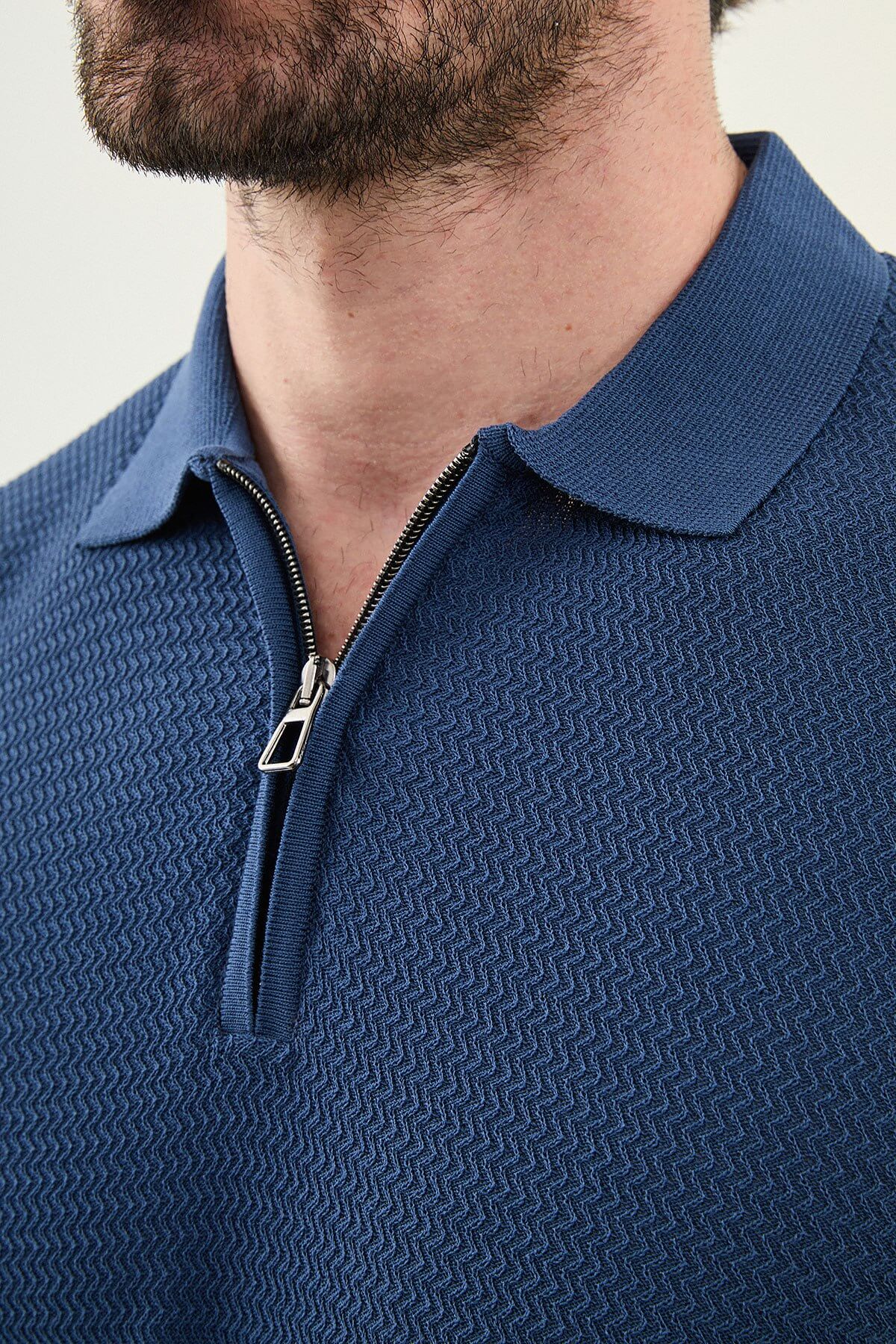 Male model wearing an indigo slim-fit quarter-zip polo T-shirt with short sleeves, styled for summer smart-casual outfits.