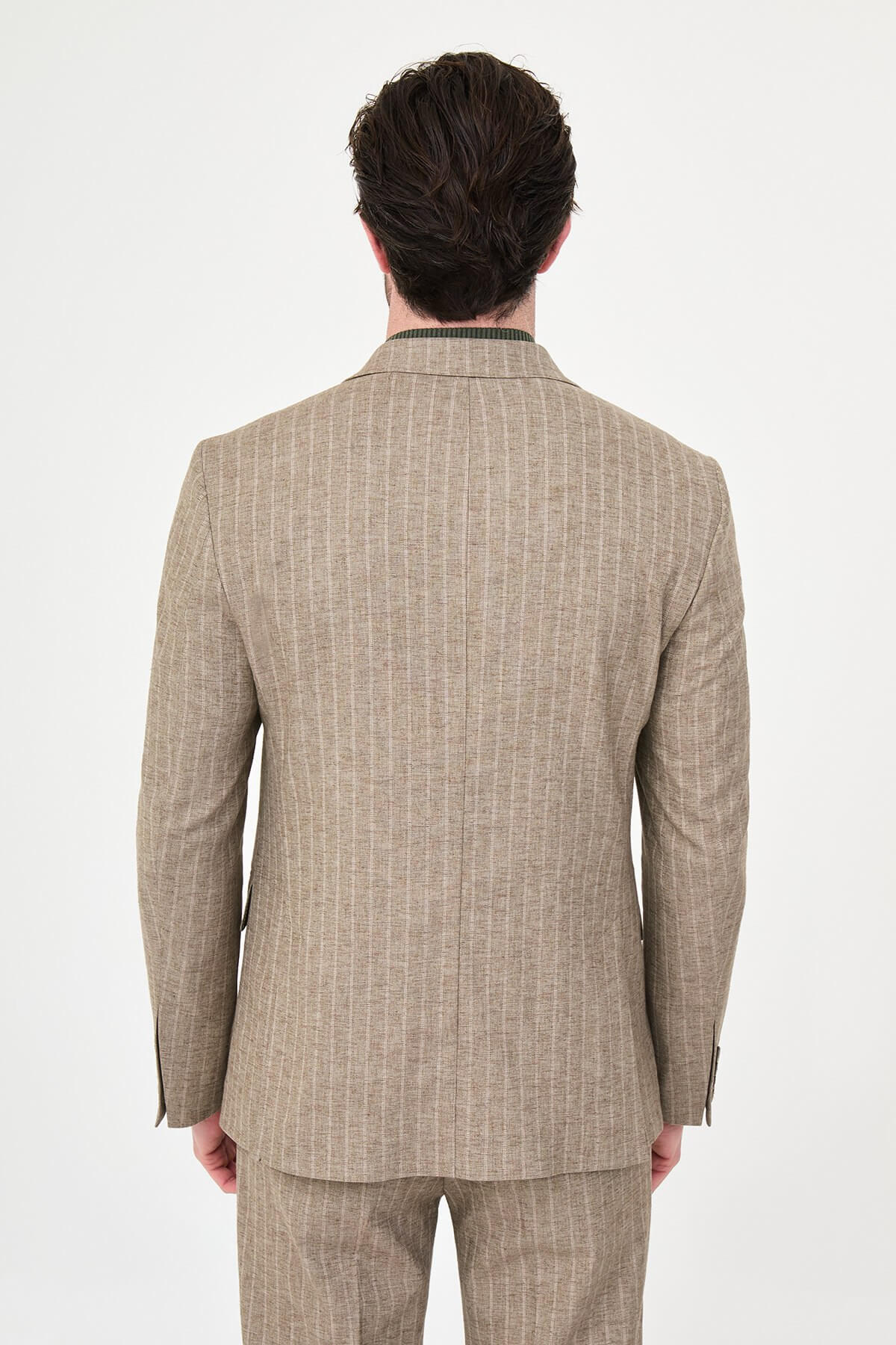 Men wearing a khaki pinstripe double-breasted slim-fit suit from the summer collection, styled with dress shoes and a green turtleneck