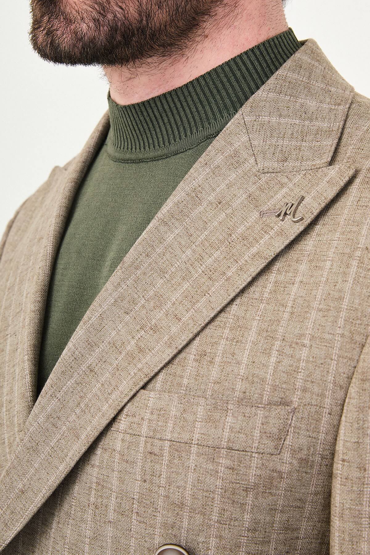 Men wearing a khaki pinstripe double-breasted slim-fit suit from the summer collection, styled with dress shoes and a green turtleneck