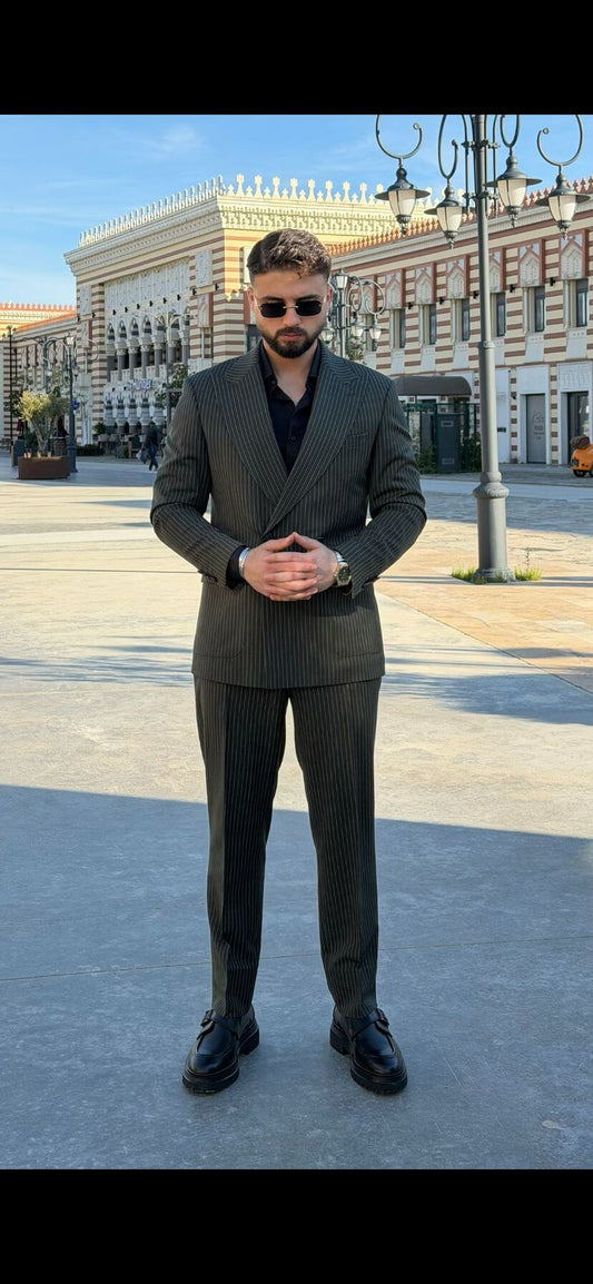 Men’s khaki pinstripe double-breasted suit styled with black shirt and loafers in a modern formal outfit outdoors