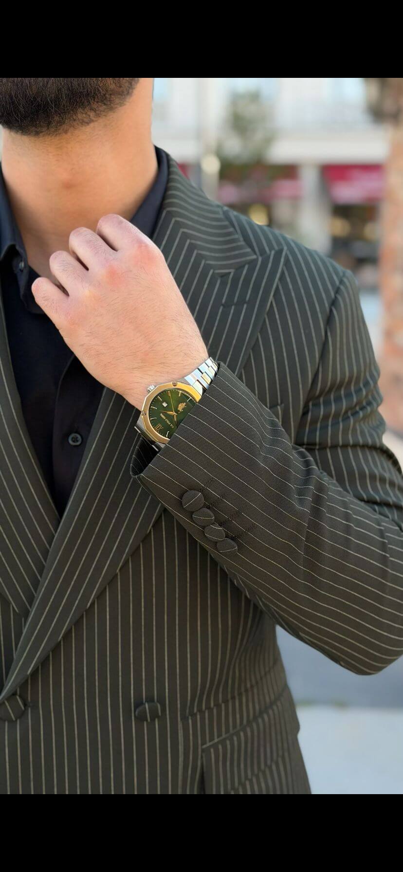 Men’s khaki pinstripe double-breasted suit styled with black shirt and loafers in a modern formal outfit outdoors