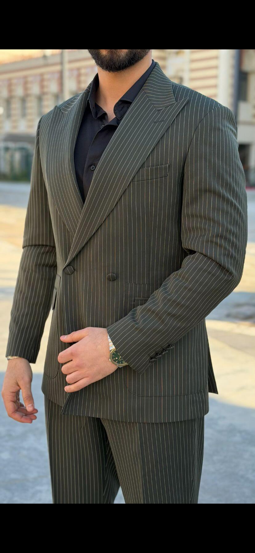Men’s khaki pinstripe double-breasted suit styled with black shirt and loafers in a modern formal outfit outdoors