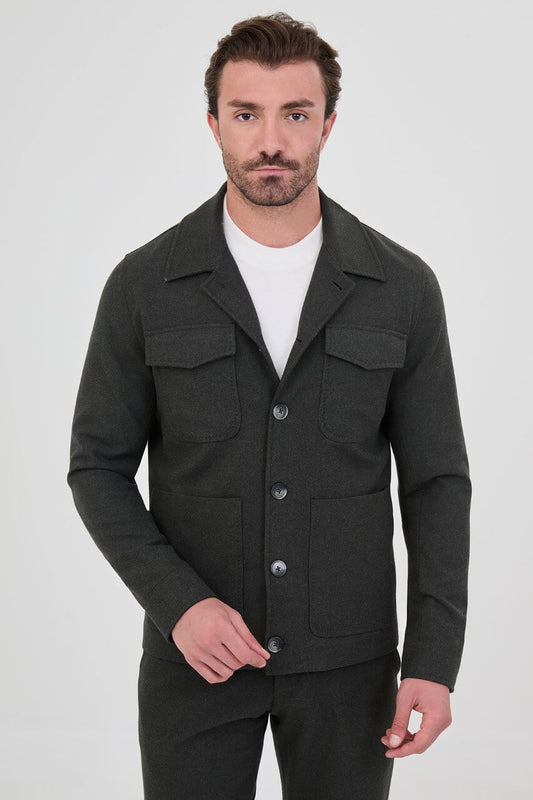 Men's dark khaki fall jacket styled with a white crew-neck shirt and matching trousers.