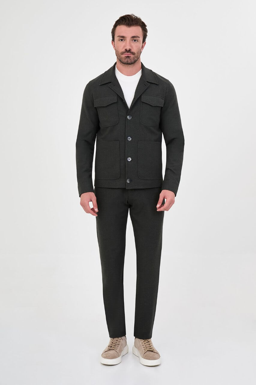 Men's dark khaki fall jacket styled with a white crew-neck shirt and matching trousers.