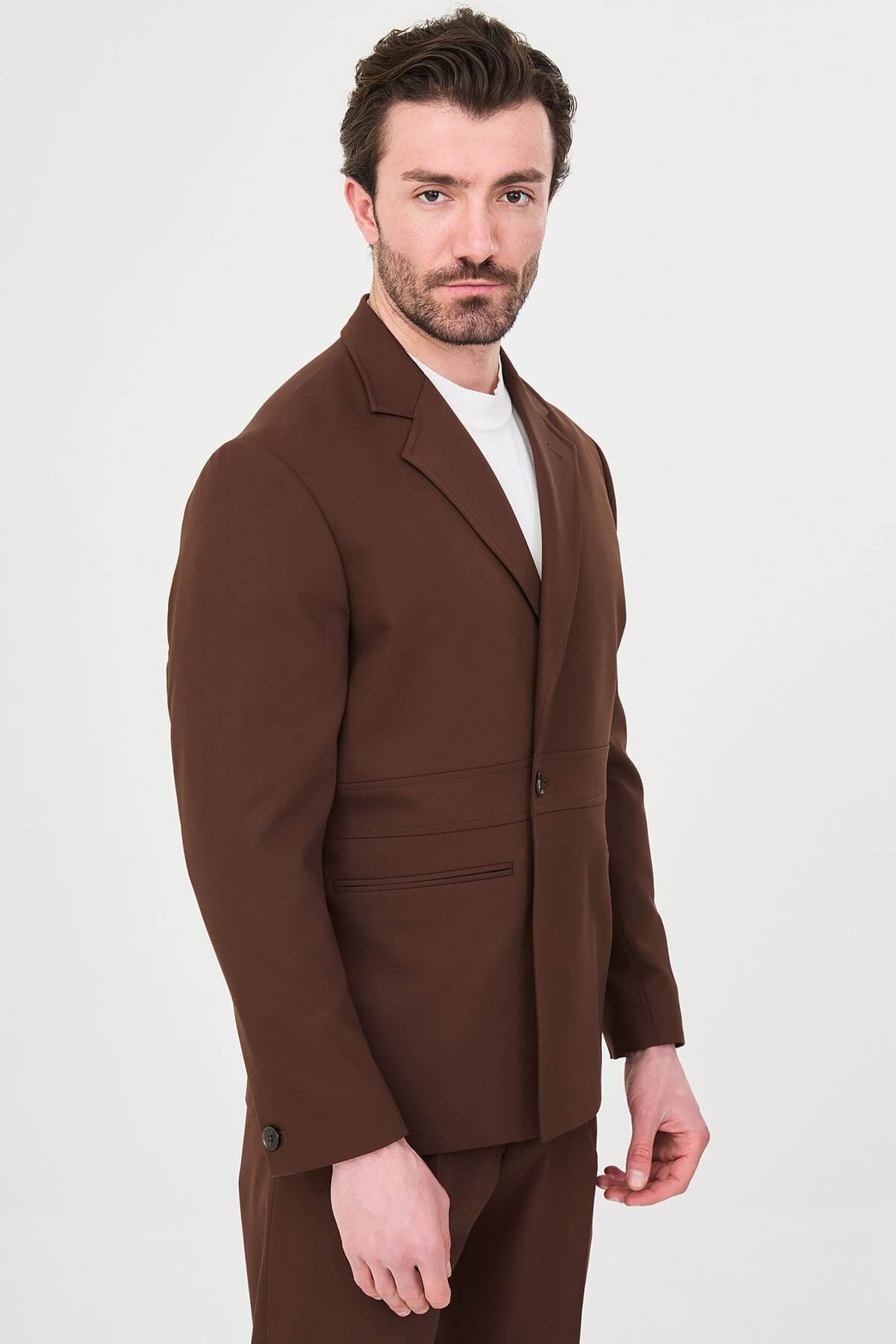 Men wearing a light brown slim fit suit with matching trousers, styled with a white crew-neck shirt, standing outdoors, showcasing a modern formal and smart-casual look.