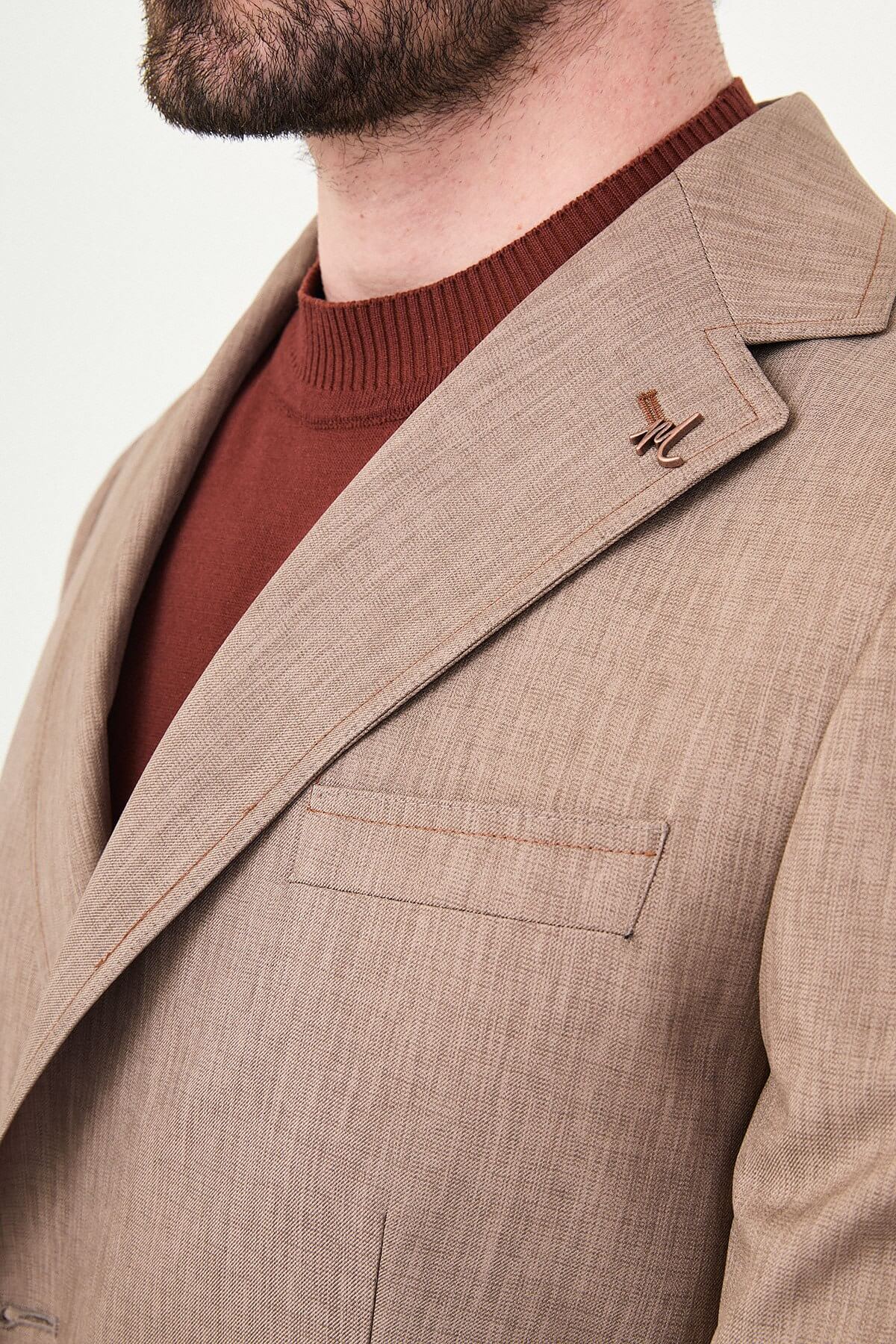 Model wearing a light brown slim-fit two-piece wedding suit with a white dress shirt, brown patterned tie, tailored trousers, and dark brown Derby shoes.