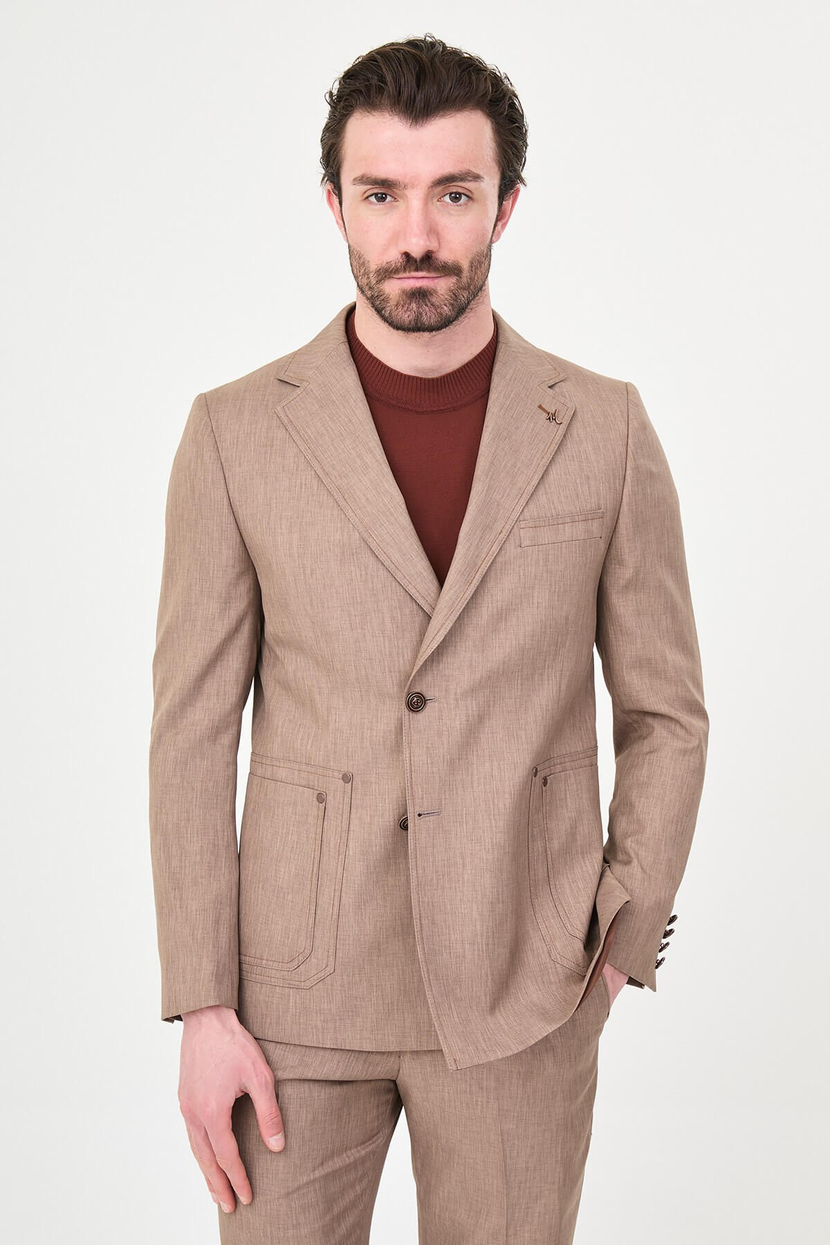 Model wearing a light brown slim-fit two-piece wedding suit with a white dress shirt, brown patterned tie, tailored trousers, and dark brown Derby shoes.