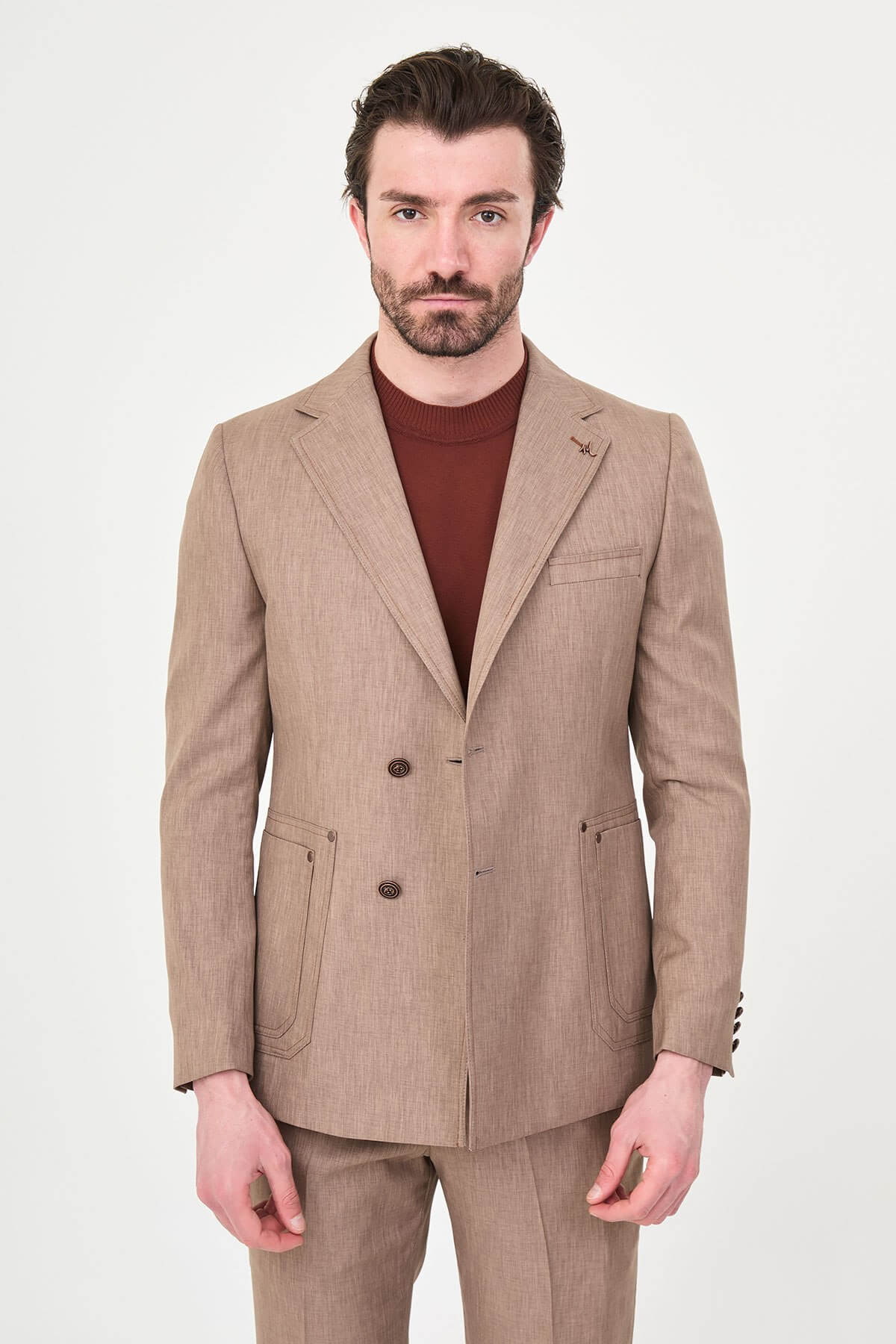 Model wearing a light brown slim-fit two-piece wedding suit with a white dress shirt, brown patterned tie, tailored trousers, and dark brown Derby shoes.