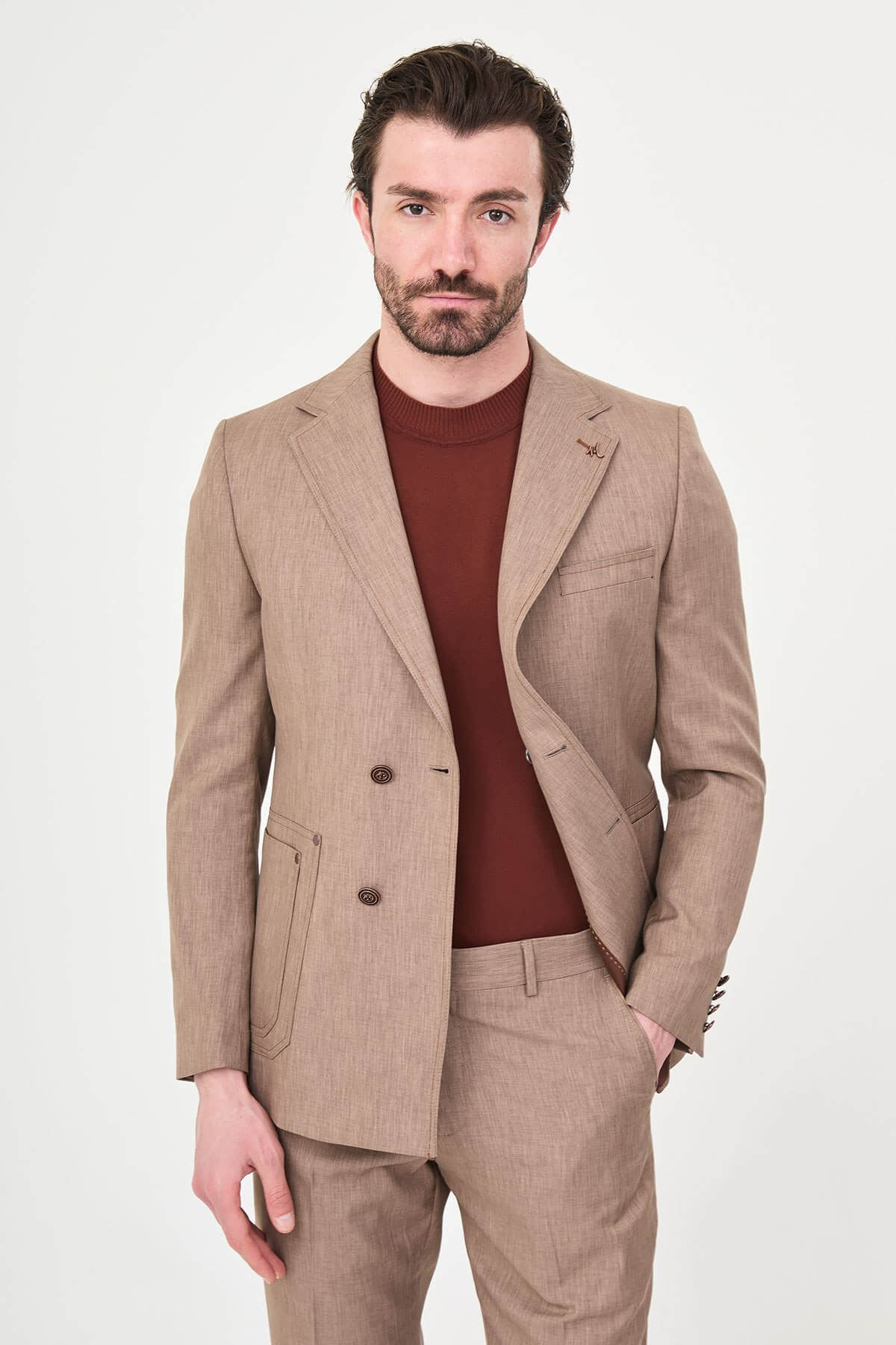 Model wearing a light brown slim-fit two-piece wedding suit with a white dress shirt, brown patterned tie, tailored trousers, and dark brown Derby shoes.
