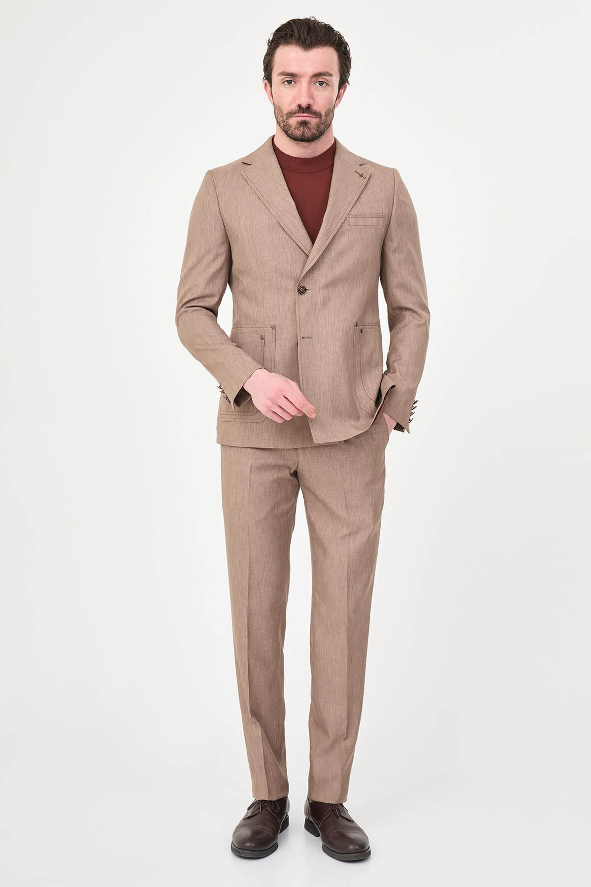 Model wearing a light brown slim-fit two-piece wedding suit with a white dress shirt, brown patterned tie, tailored trousers, and dark brown Derby shoes.