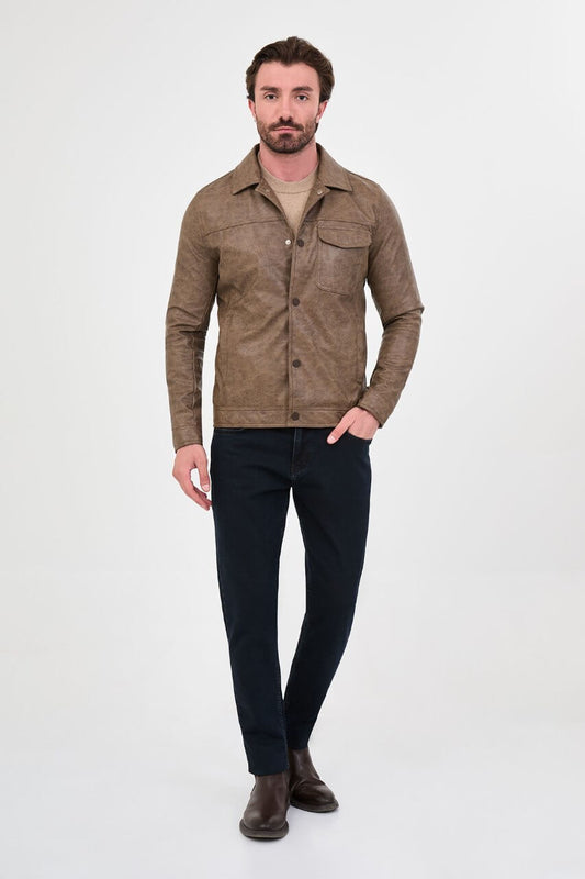 Men's mink-brown PU leather jacket styled with dark jeans, a beige sweater and brown boots.