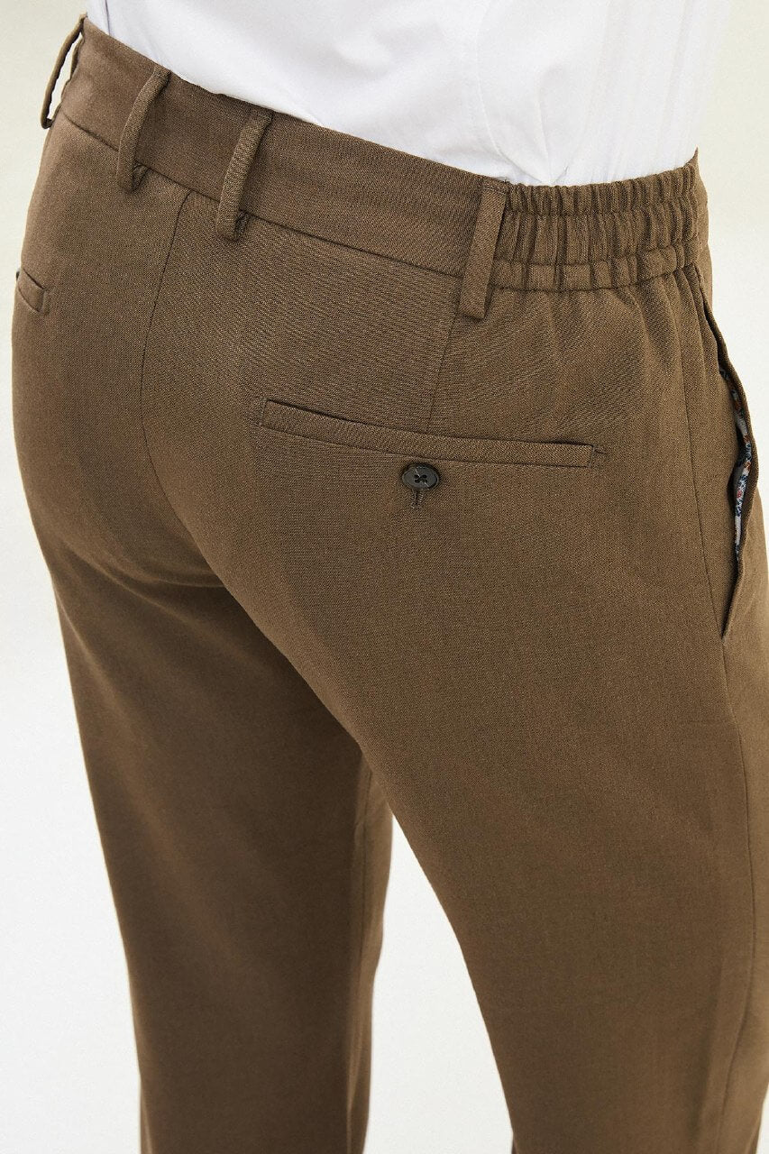 Men wearing mink slim-fit drawstring trousers with elastic waistband, styled with sneakers and dress shoes for versatile summer menswear.