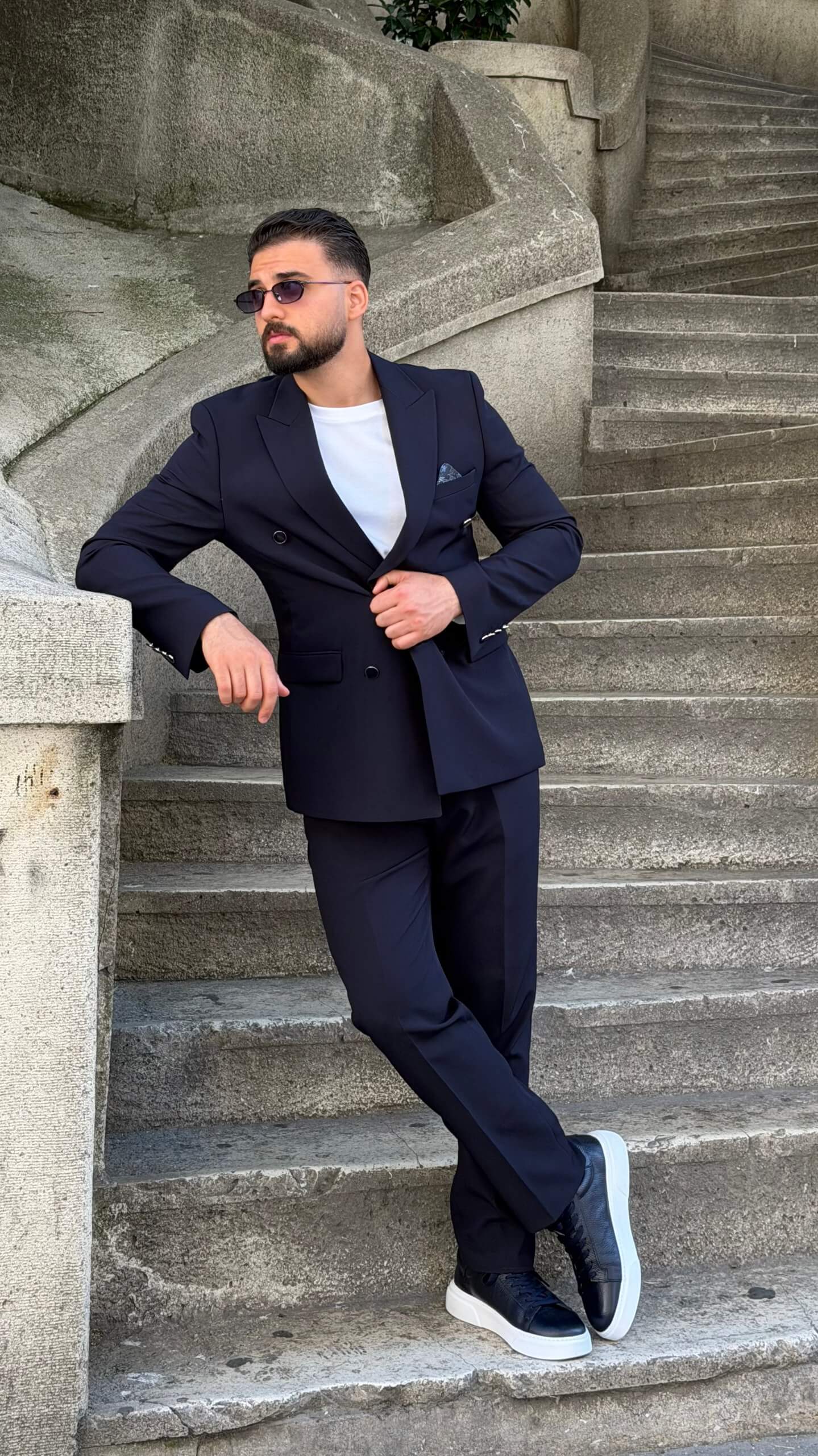 Men’s navy blue double breasted suit with peak lapels, tailored jacket, matching trousers, and modern formal style for weddings and business occasions.