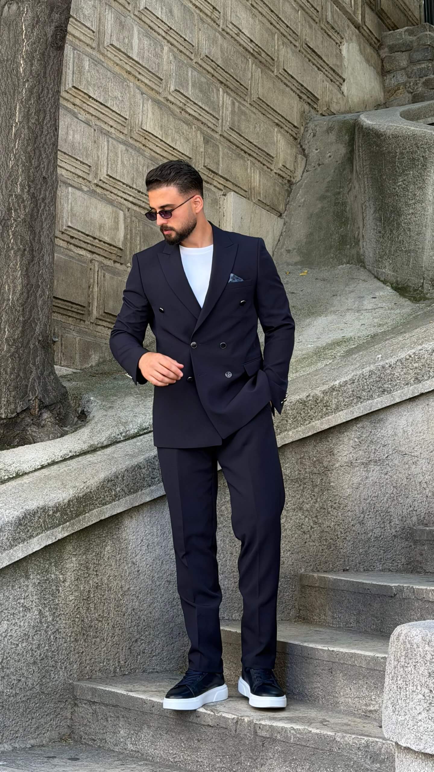 Men’s navy blue double breasted suit with peak lapels, tailored jacket, matching trousers, and modern formal style for weddings and business occasions.