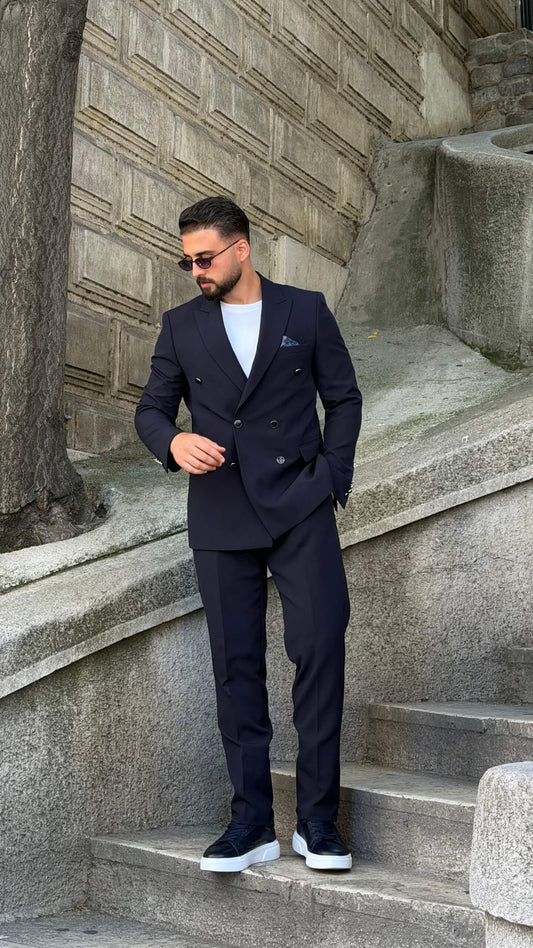Men’s navy blue double breasted suit with peak lapels, tailored jacket, matching trousers, and modern formal style for weddings and business occasions.