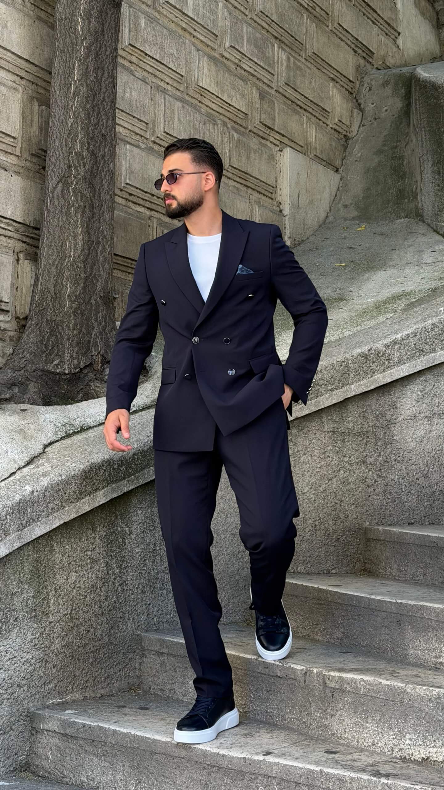Men’s navy blue double breasted suit with peak lapels, tailored jacket, matching trousers, and modern formal style for weddings and business occasions.