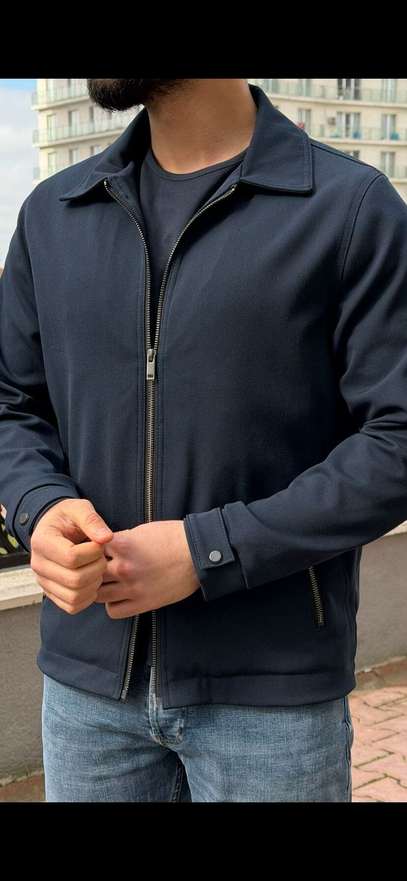 Men’s navy blue zip-up jacket with tailored fit and minimalist design, smart casual outerwear styled with denim jeans