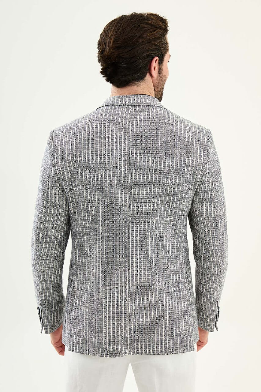 Men’s navy blue slim fit cotton linen blazer with a lightweight textured finish, styled with white trousers for smart casual summer elegance.