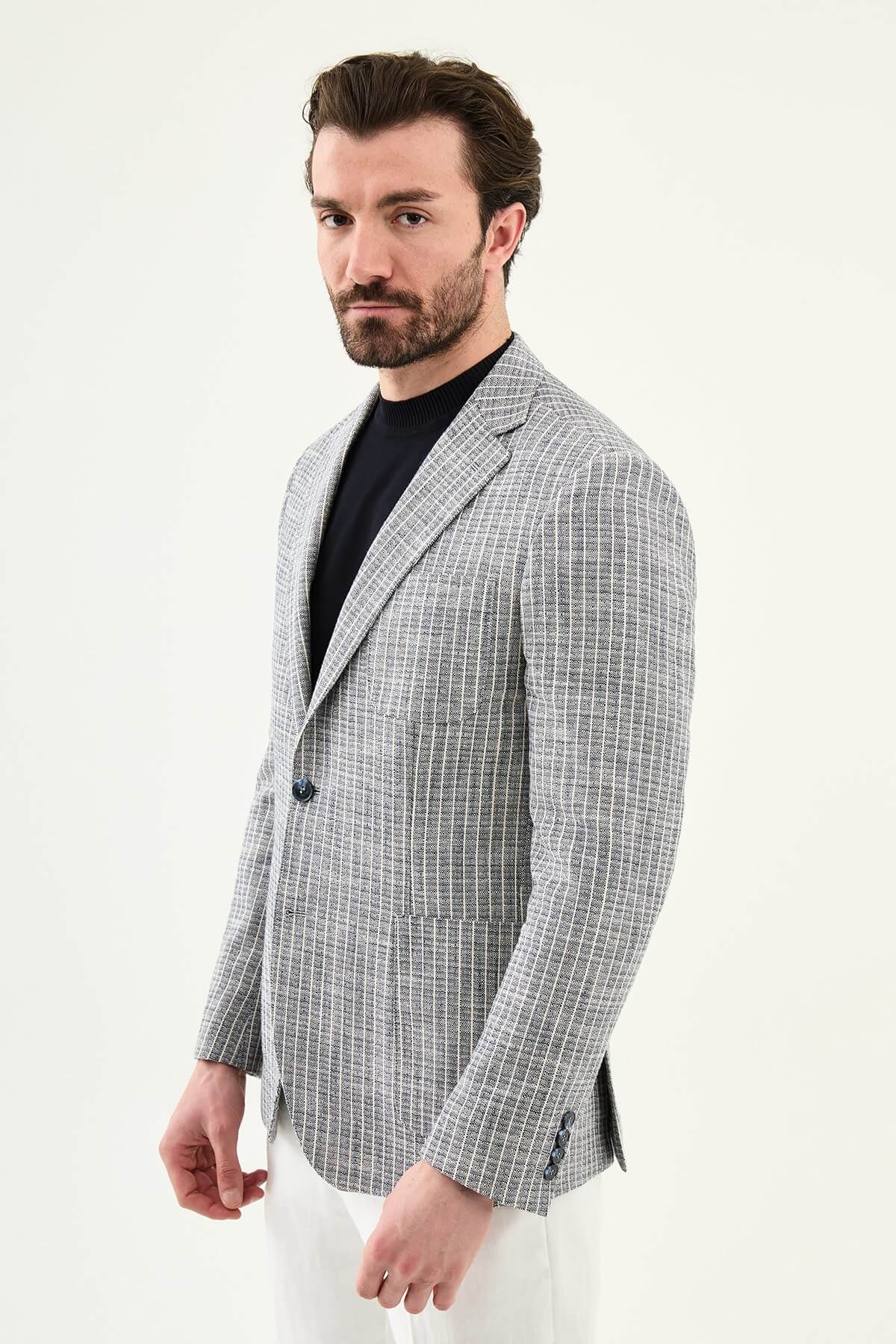 Men’s navy blue slim fit cotton linen blazer with a lightweight textured finish, styled with white trousers for smart casual summer elegance.