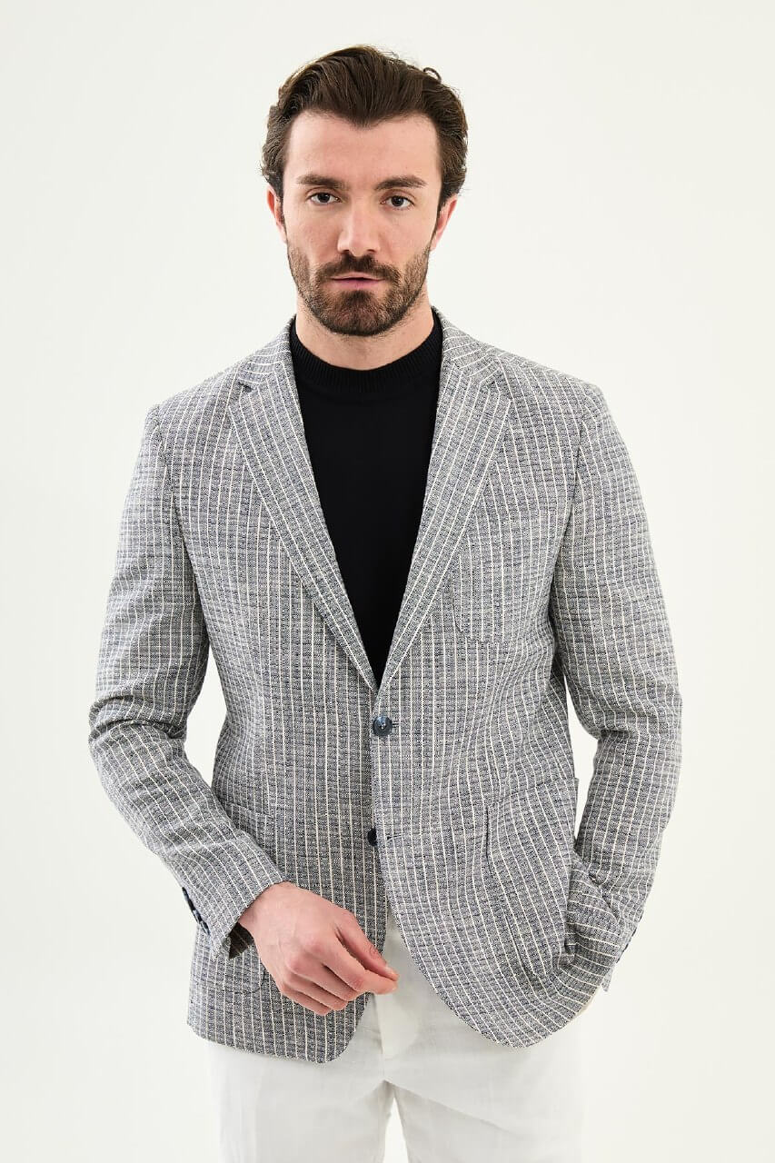 Men’s navy blue slim fit cotton linen blazer with a lightweight textured finish, styled with white trousers for smart casual summer elegance.