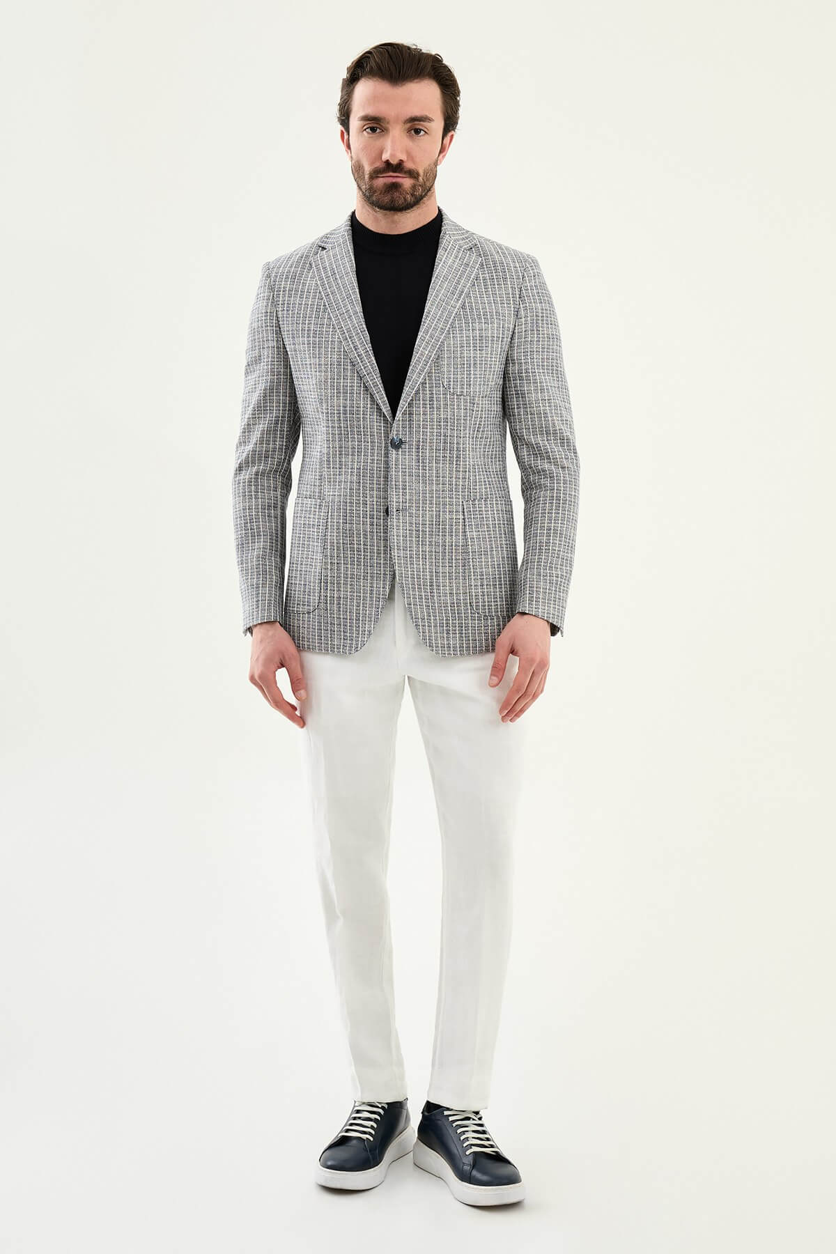 Men’s navy blue slim fit cotton linen blazer with a lightweight textured finish, styled with white trousers for smart casual summer elegance.