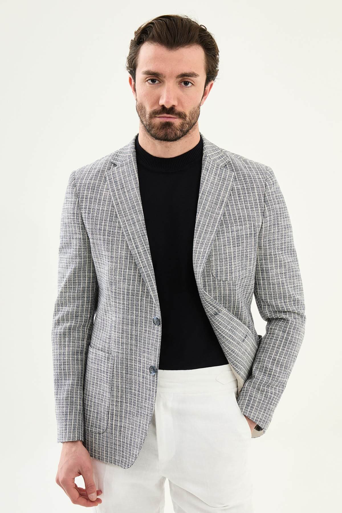 Men’s navy blue slim fit cotton linen blazer with a lightweight textured finish, styled with white trousers for smart casual summer elegance.