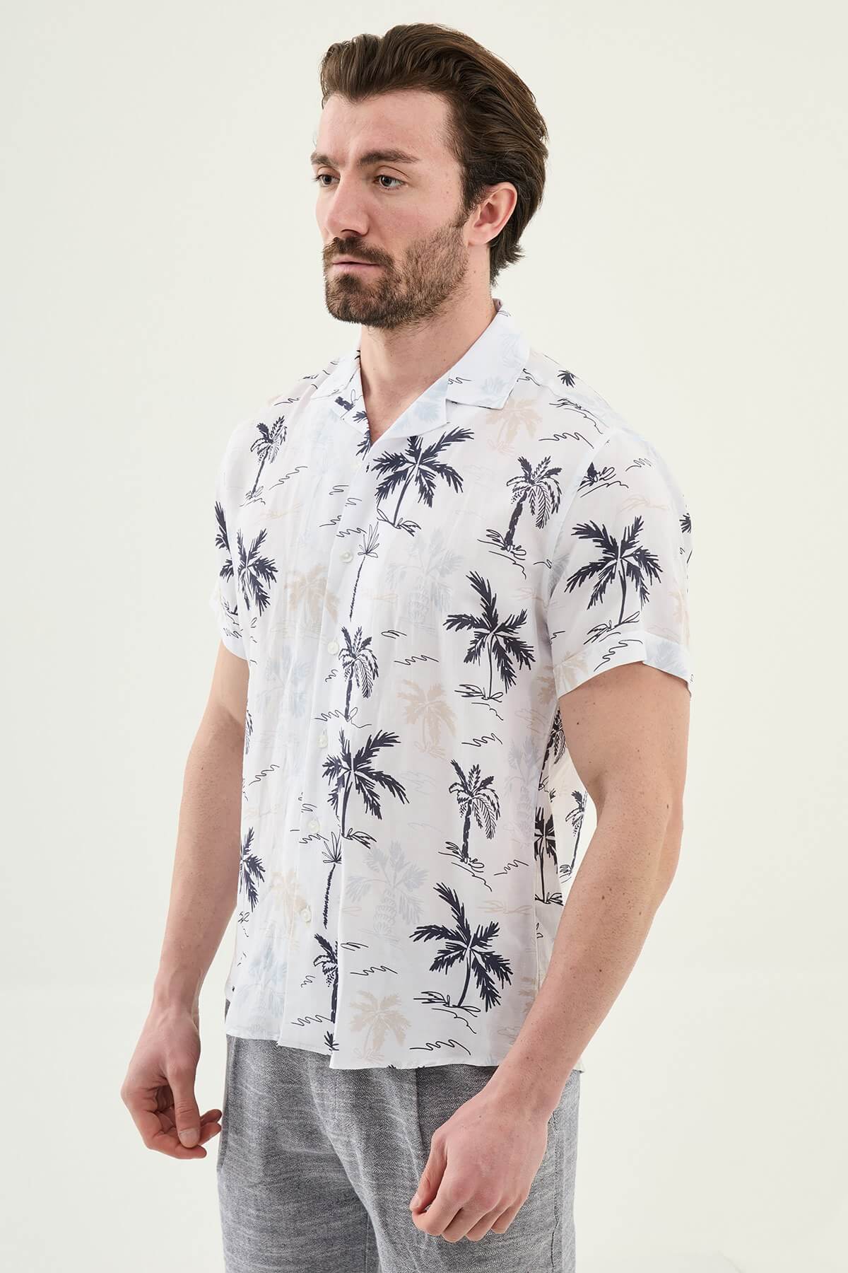 Men’s navy blue palm tree print short sleeve shirt in a lightweight Tencel and linen blend with a relaxed summer resort style.