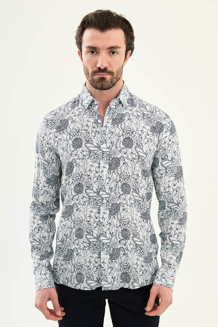 Man wearing a navy blue patterned slim-fit long sleeve shirt, standing front-facing, styled with dark trousers.